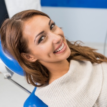 Smiling young woman leaning back in dental chair