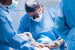 an oral surgeon performing dental implant placement surgery