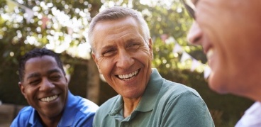 Three men laughing together outdoors