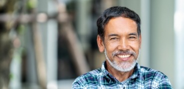 Older man in blue plaid shirt smiling