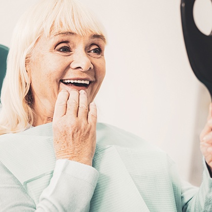 a patient admiring her new dentures