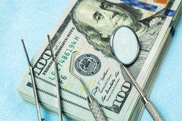 Dental tools on a pile of money