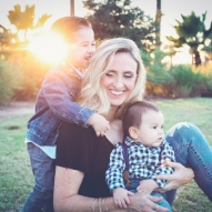 Mother sitting in grass with her two young sons