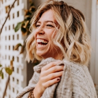 Woman in gray sweater laughing