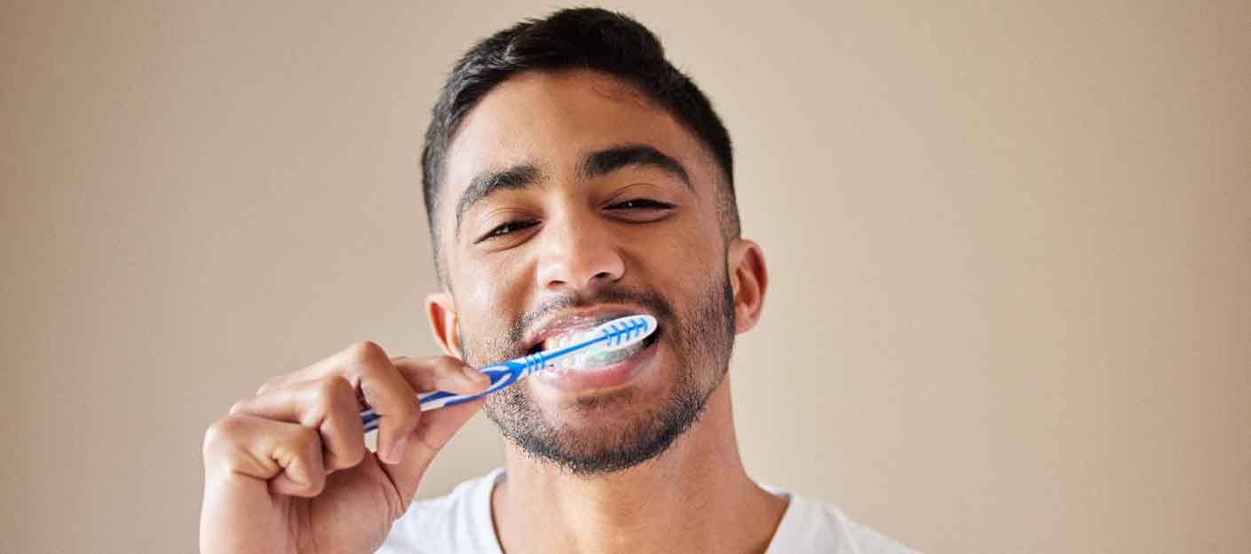 a man applying whitening gel to a dental tray in his bathroom