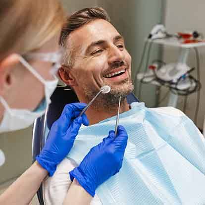 a woman being fitted for whitening trays at a dental office