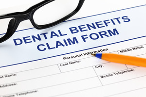 Dental benefits claim form with glasses and pen