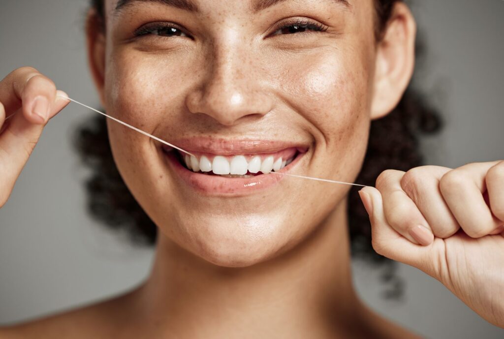 A woman flossing her teeth